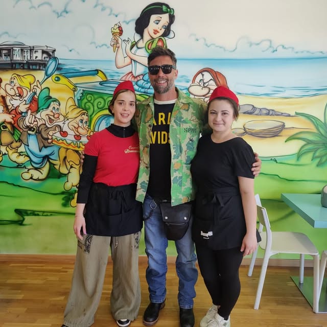 Il team di Gelateria Biancaneve davanti al murale della gelateria